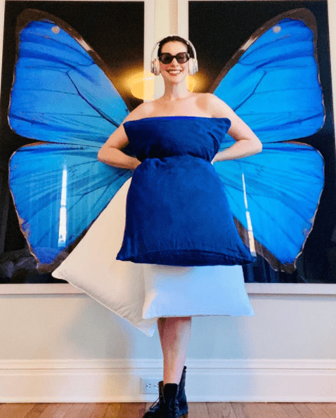 Anne Hathaway dressed up in white and blue pillows